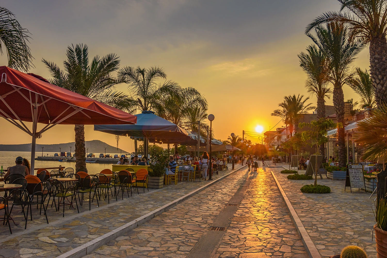 Bustling pedestrian street in Gialova, lined with an array of local boutiques, cafes, and eateries, offering a lively atmosphere for leisurely strolls and authentic Greek dining experiences.
