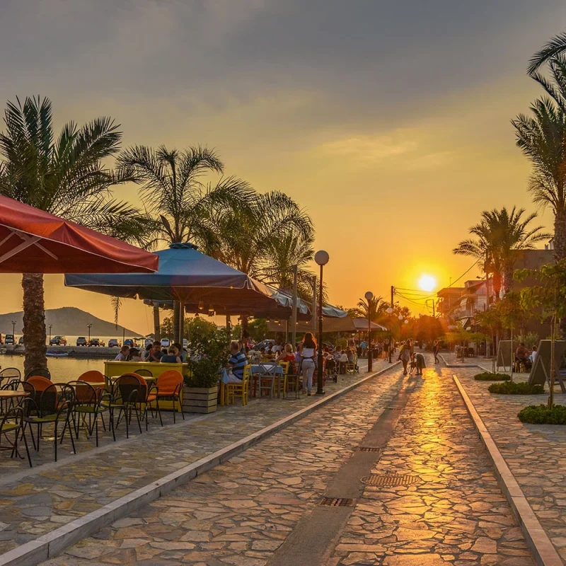 Bustling pedestrian street in Gialova, lined with an array of local boutiques, cafes, and eateries, offering a lively atmosphere for leisurely strolls and authentic Greek dining experiences.
